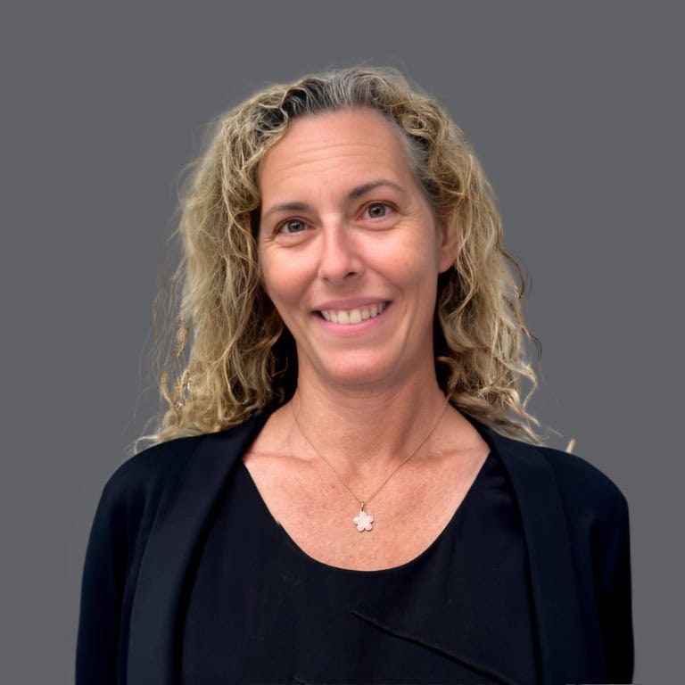 Headshot of Christine Burke, O.D. in professional wear with a grey background. 