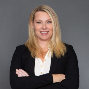 Headshot of Dr. Kathryn B. Freidl in professional wear with a grey background.
