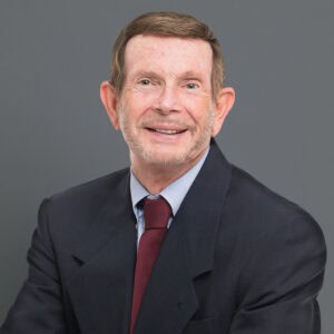 Headshot of Dr. Jerry Maida in professional wear with a grey background.