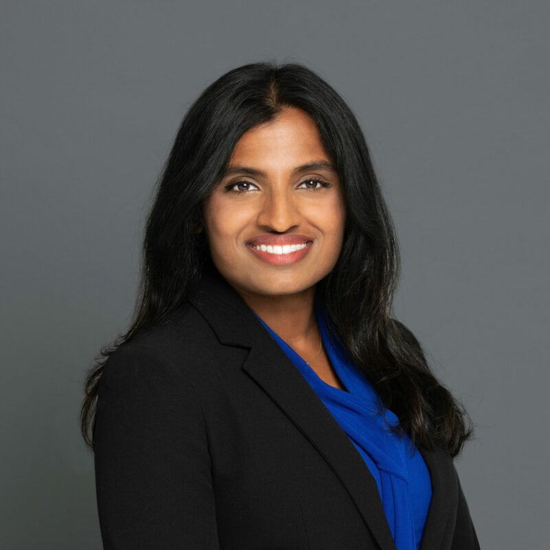 Headshot of Dr. Francis in professional wear with a grey background.