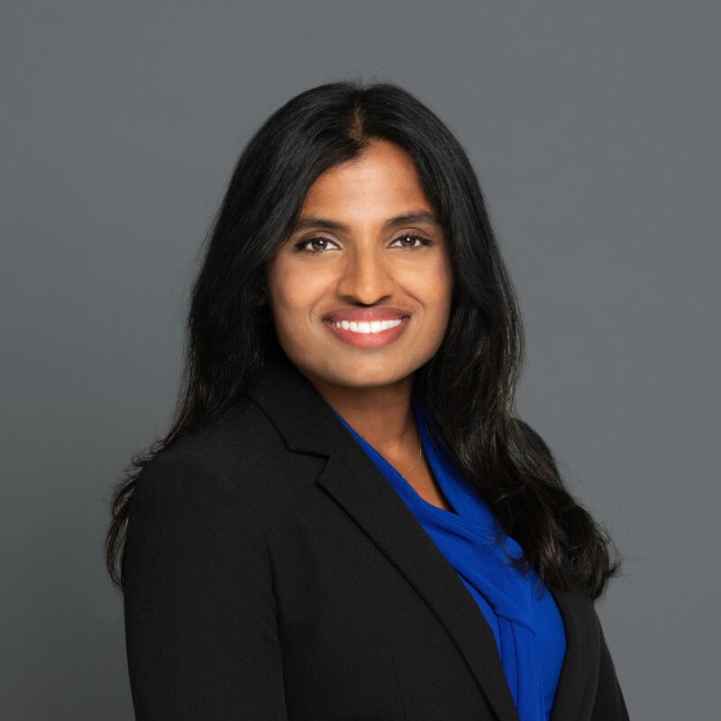 Headshot of Dr. Francis in professional wear with a grey background.
