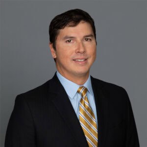 Headshot of Dr. Kenzo Koike in professional wear with a grey background.