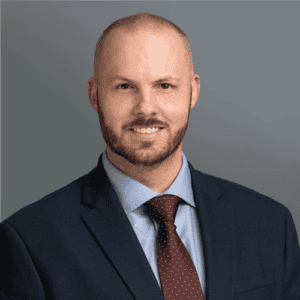 Headshot of Dr. Norman's in professional wear with a grey background.