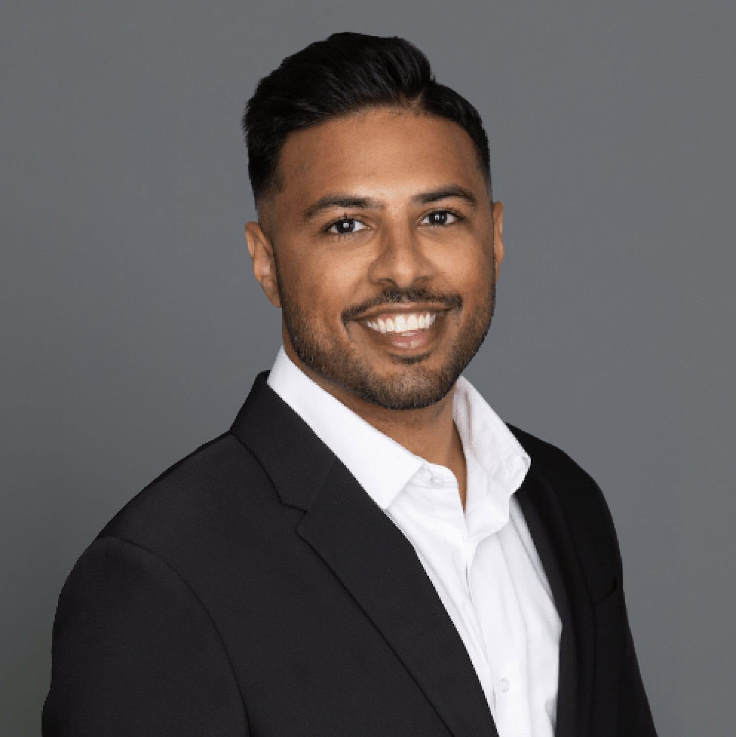 Headshot of Dr. Omar-Gayasaddin in professional wear with a grey background.