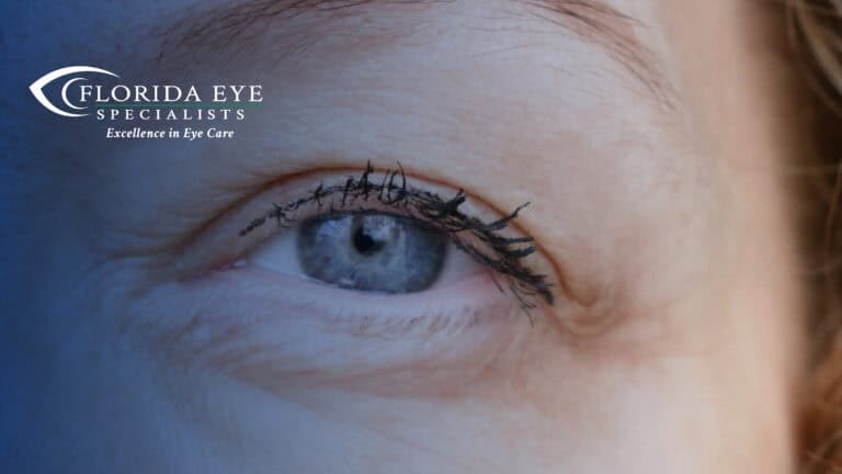 photograph of a blonde women's blue eye. The image has a blue shadow overlay with the Florida Eye Specialists logo in the top left corner.