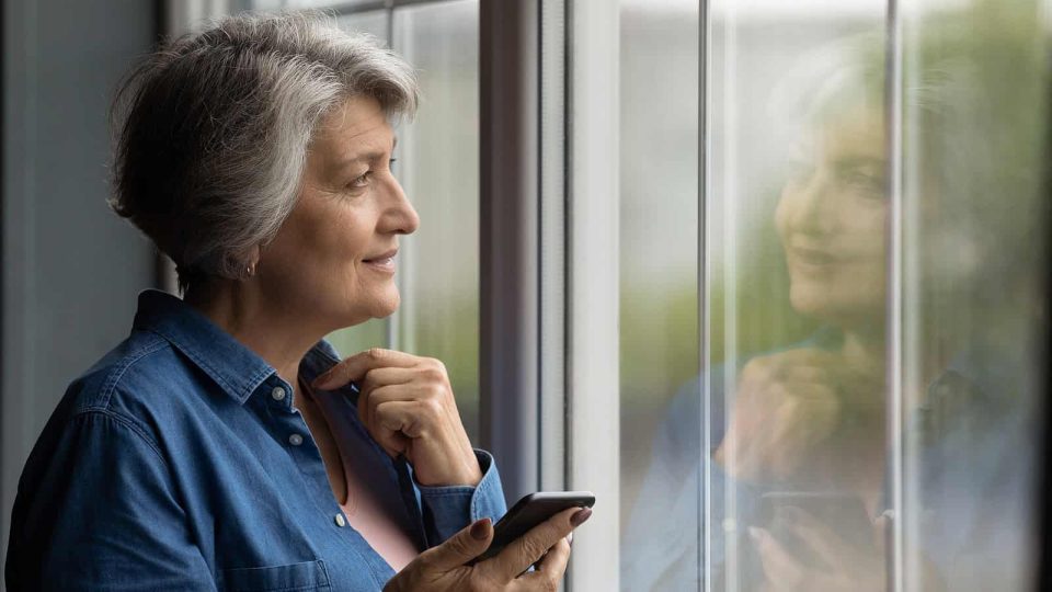 A senior woman looks out the window