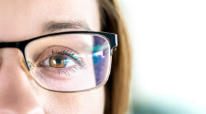 A close-up of a woman's brown eyes. She is wearing glasses